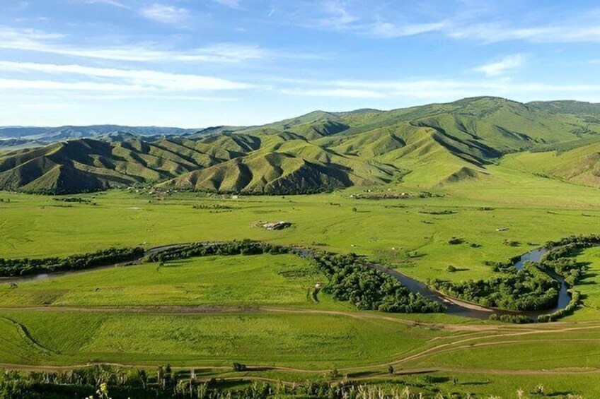 Rolling green hills, a winding river, and a small settlement in the valley. 4