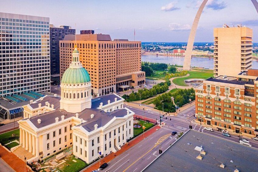 A cityscape with a prominent dome building, a large arch bridge, and modern high-rise buildings. 4