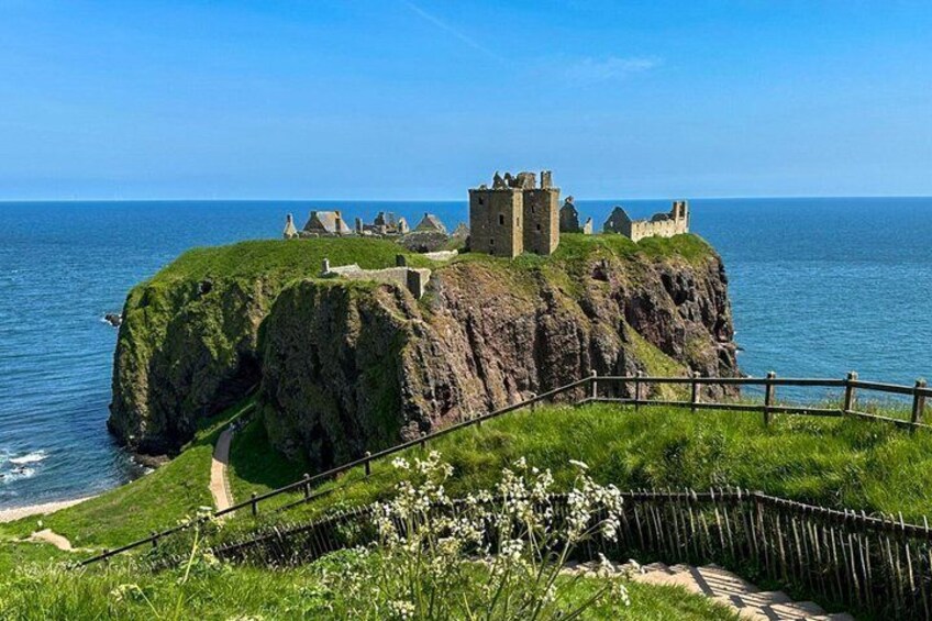 Un château côtier, perché sur une falaise verdoyante qui surplombe la mer. 4