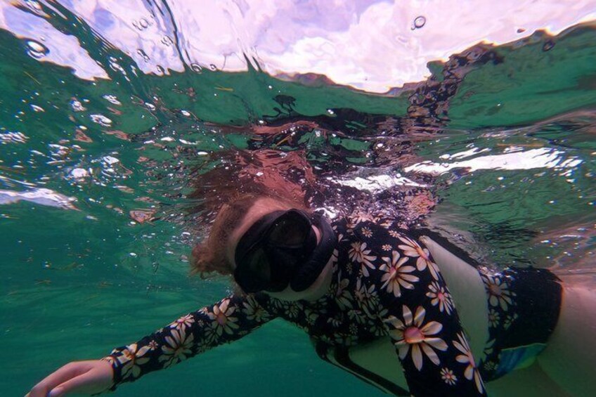 A person swimming underwater with a floral swimsuit. 3