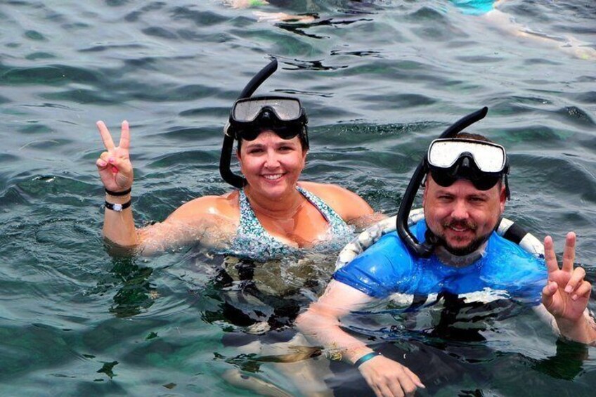 Two people snorkeling in clear water, wearing diving masks and fins. 5