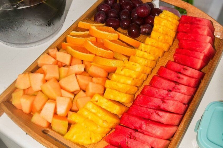 Un tagliere con frutta a fette, tra cui anguria, melone cantalupo, ananas e uva. 4