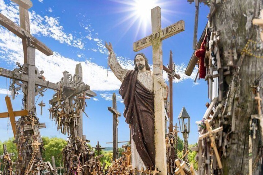 A statue of Jesus with a cross, surrounded by numerous crosses and religious icons. 4