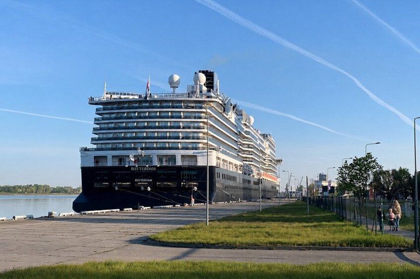 A large cruise ship docked at a port with a clear sky and calm sea. 5