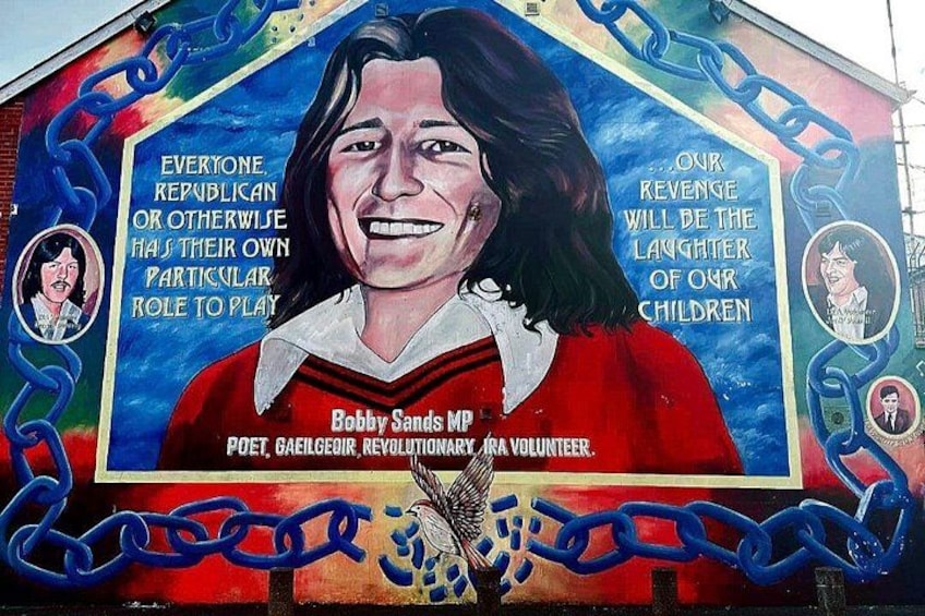 A mural with a person wearing a red shirt, chains, and text about Bobby Sands. 2