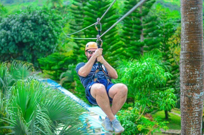 A person zip-lining through a lush, tropical forest. 1