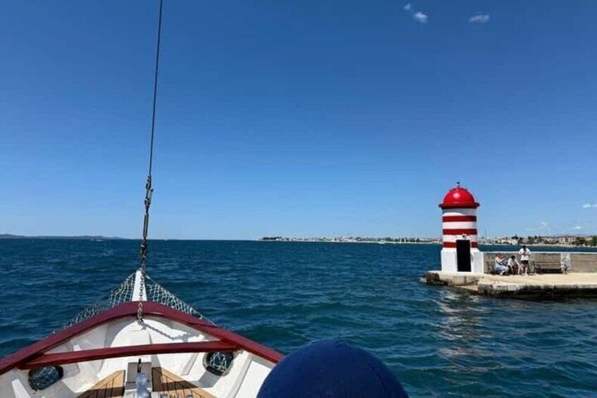 A boat with a red and white striped lighthouse in the background. 5