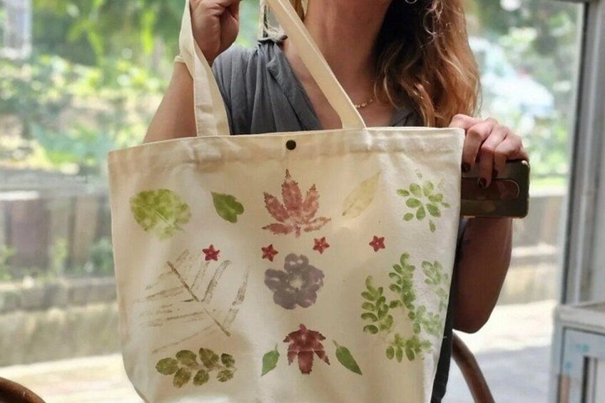 Una persona che tiene una borsa di tela con motivi floreali. 2