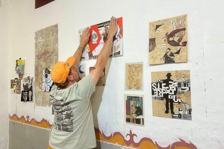 A person hanging posters on a wall. 2