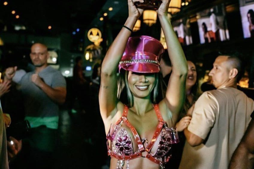 Una persona con sombrero rojo y blusa adornada, sosteniendo un trofeo. 4