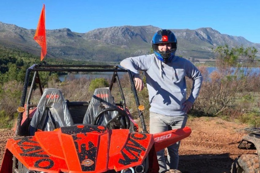 En person står ved siden af en dune buggy foran et bjergrigt landskab. 4