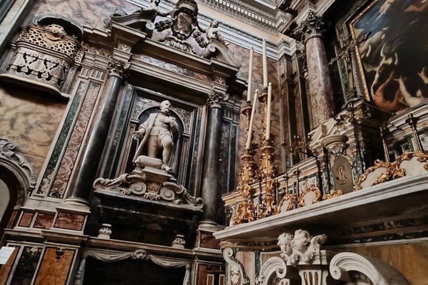 An ornate architectural interior with a central statue, intricate carvings, and classical columns. 2