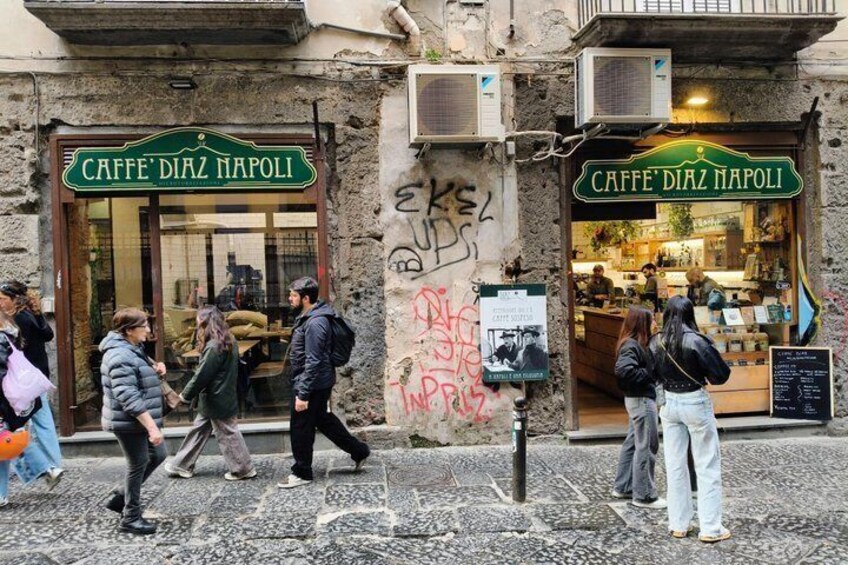 Eine Straße mit einem Café namens 'CAFFE' DIAZ NAPOLI und einem Schild. 5