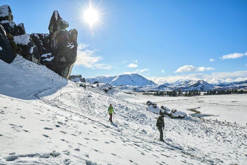 A snowy mountain landscape with a clear sky and a person hiking. 3