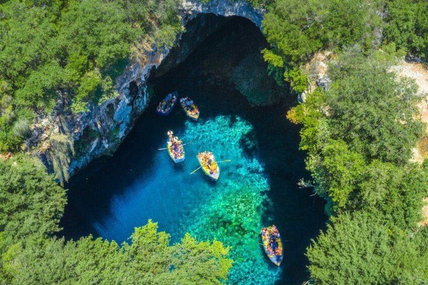 A group of canoes on a clear turquoise water body surrounded by dense green forest. 1
