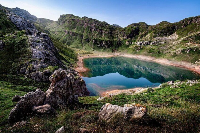 A mountain lake surrounded by rocky terrain and lush greenery. 4