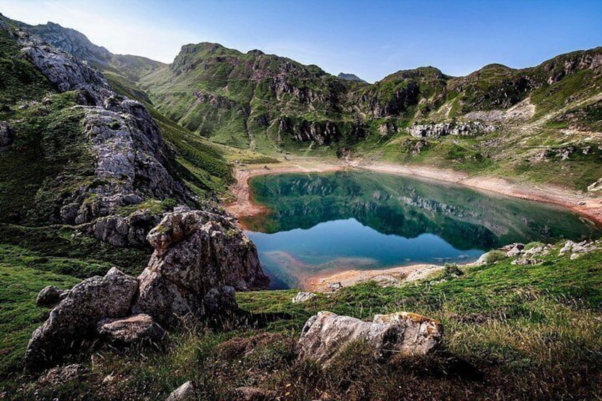 A mountain landscape with a lake surrounded by rocky terrain and greenery. 4