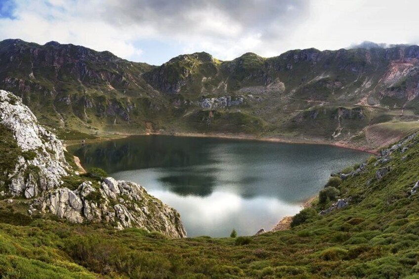 A mountain lake surrounded by rocky terrain and greenery. 1