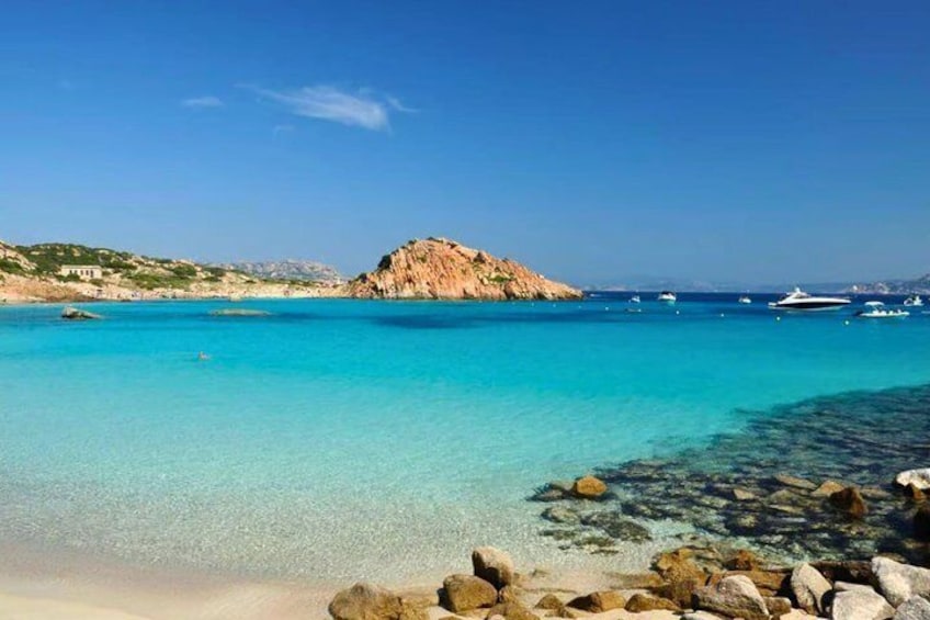 Un mar turquesa, costa rocosa y una pequeña isla. 5