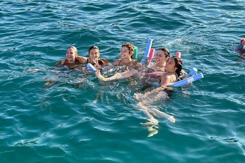 People floating on water with blue and pink floating devices. 2