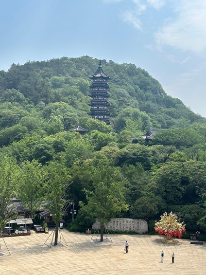 A pagoda on a hill with a park in the foreground. 3