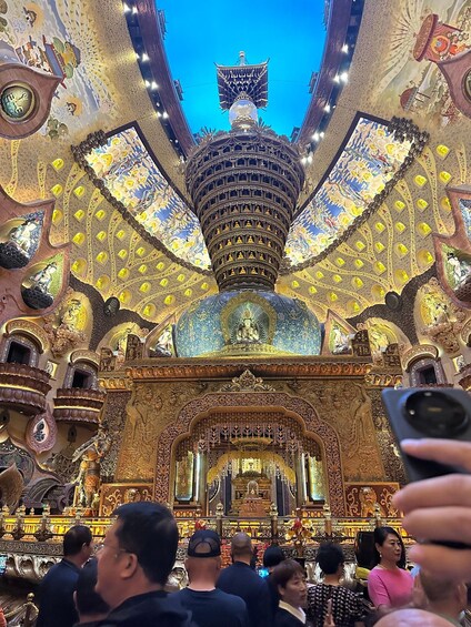An ornate temple interior with intricate golden decorations and a central statue. 4