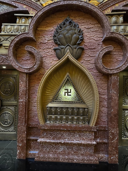 A detailed architectural structure with ornate carvings and a central emblem. 3