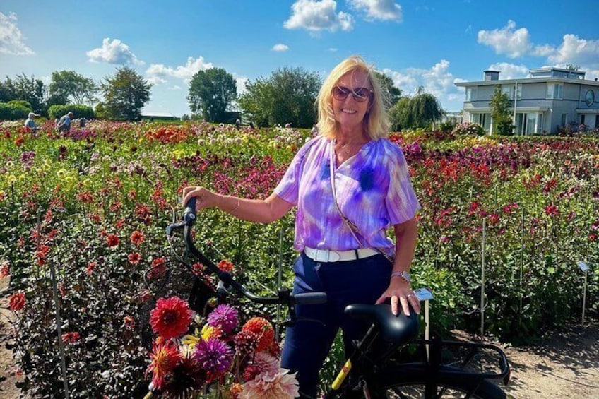 Eine Person steht in einem Blumenfeld mit einem Fahrrad. 1