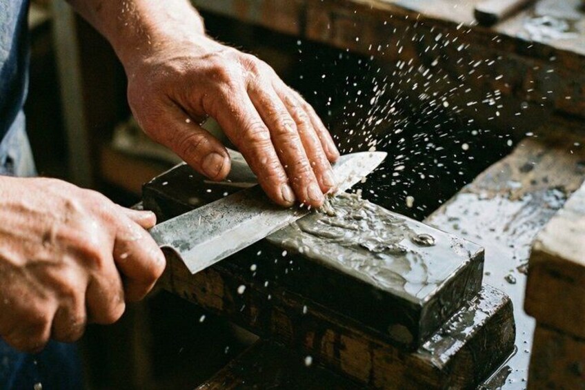 Hands sharpening a knife on a whetstone. 2