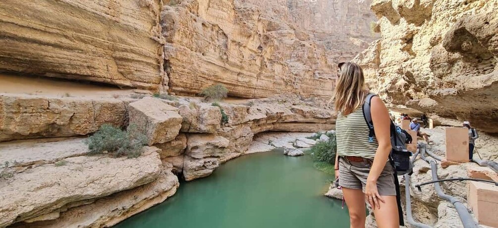 A canyon with a river, rocky cliffs, and a person standing by the river. 5