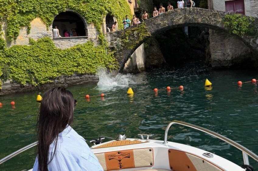 Un bateau sur une rivière, avec un pont de pierre et des personnes à bord. 3