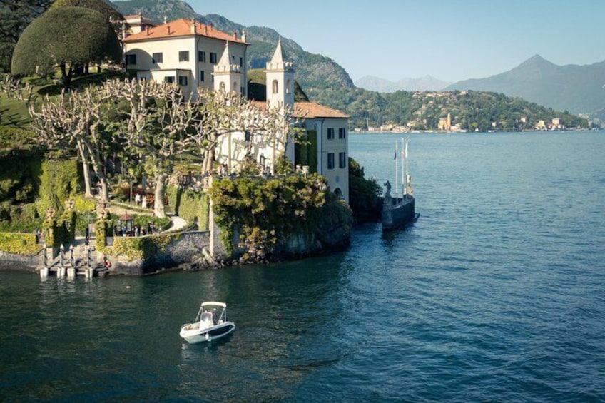 Un lac avec un bateau, une maison avec un toit rouge et des montagnes en arrière-plan. 5