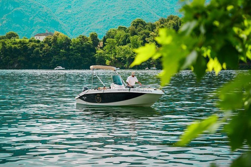 A boat on a lake with a forested mountain in the background. 3