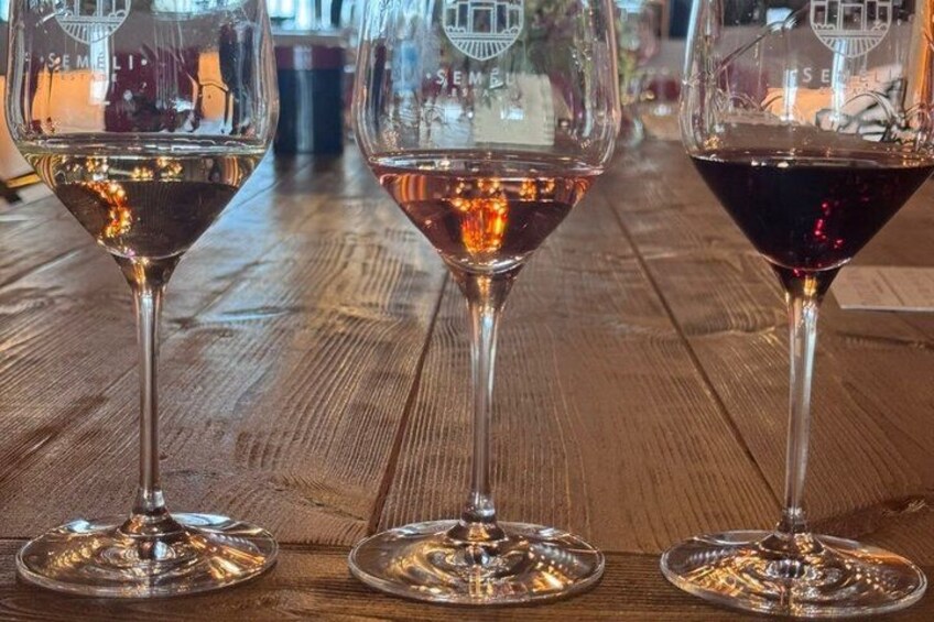 Three wine glasses on a wooden table. 5