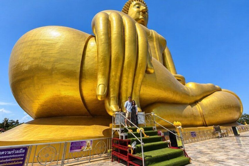 A large golden Buddha statue with a staircase leading up to it. 1