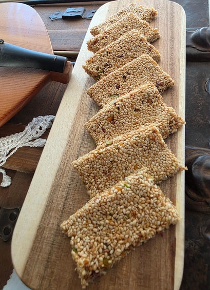 A wooden board with sesame seed bars arranged in a row. 4