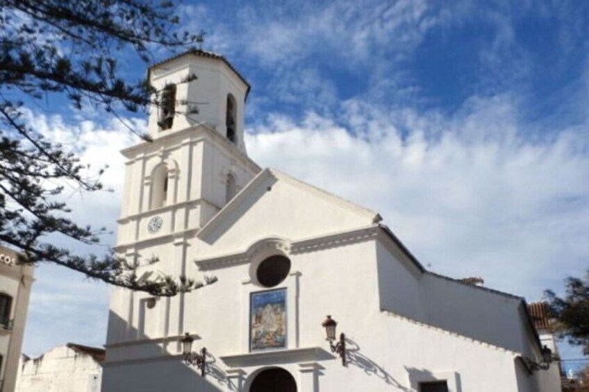 En hvid kirke med et kirketårn og et rundt vindue. 4
