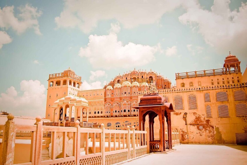A historic building with ornate architecture, including domes and arches, and a clear sky with clouds. 4