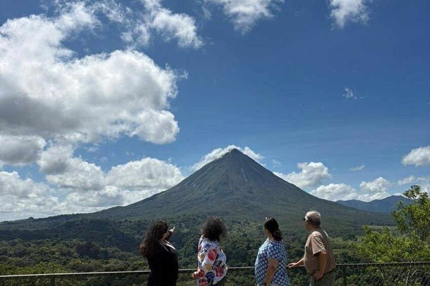 A group of people observing a volcano from a viewing platform. 4