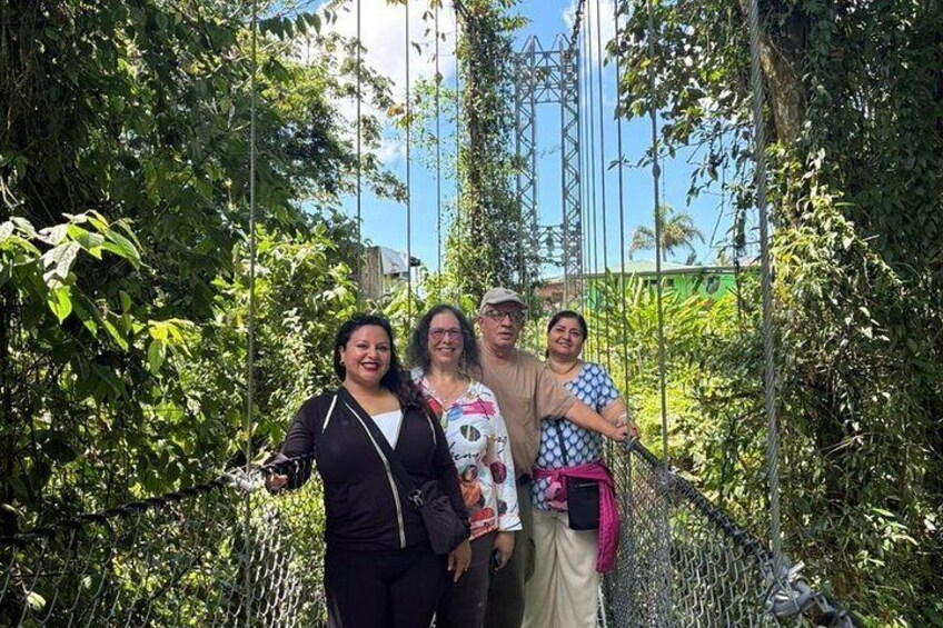 A group of people standing on a bridge surrounded by dense foliage. 3