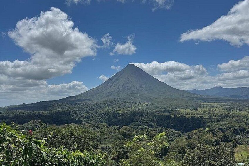 A mountain with a conical shape, surrounded by dense green forest. 2