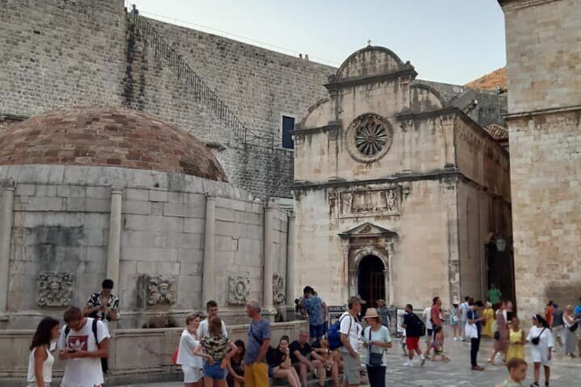Un edificio storico con una cupola e una torre dell'orologio, circondato da una folla di persone. 5