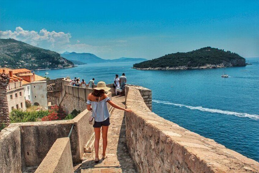 Paesaggio costiero con un'antica fortificazione, un mare blu limpido e una piccola isola all'orizzonte. 4