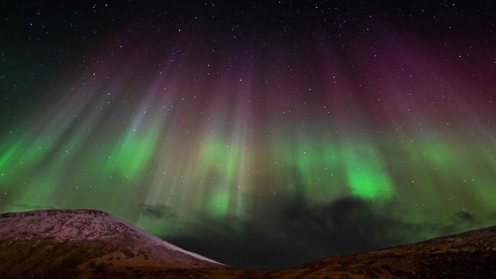 The Northern Lights over a mountainous landscape. 5