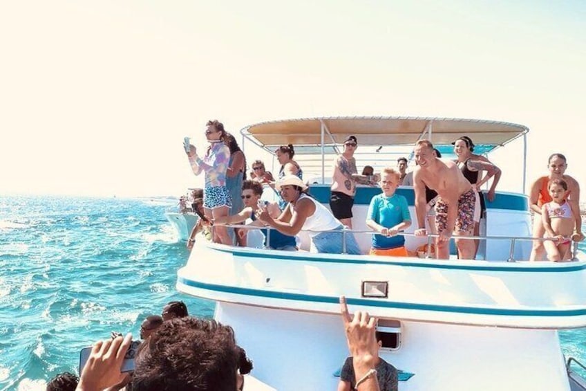 Un grupo de personas en un bote con una vista despejada del océano. 4