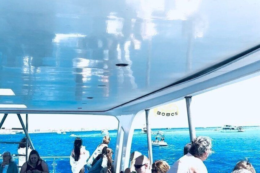 Un barco con pasajeros, un mar azul y transparente, y barcos a lo lejos. 5