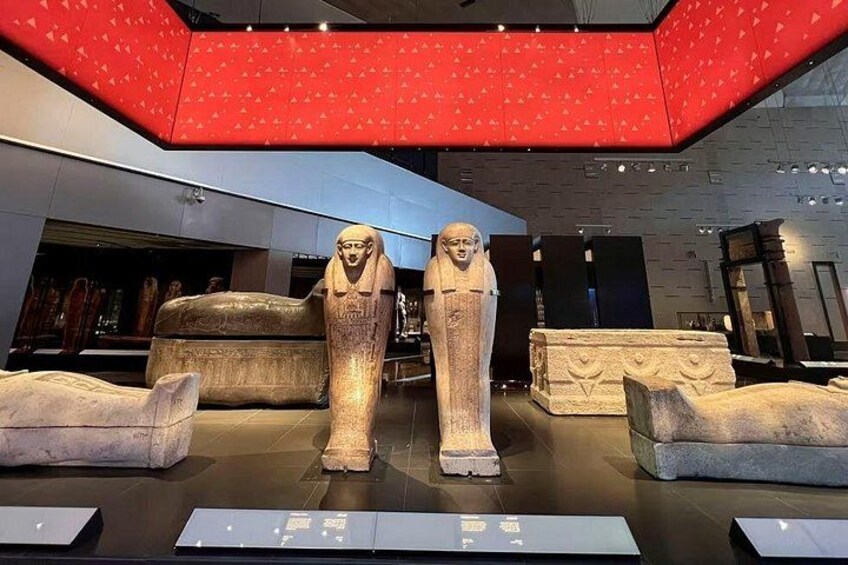 Una exposición de museo con sarcófagos y estatuas del antiguo Egipto. 2