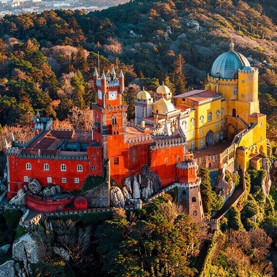 A castle with red and yellow buildings, surrounded by trees and hills. 2