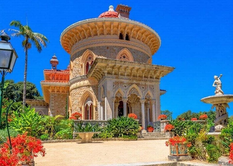 A historic building with ornate architecture, a fountain, and lush greenery. 1