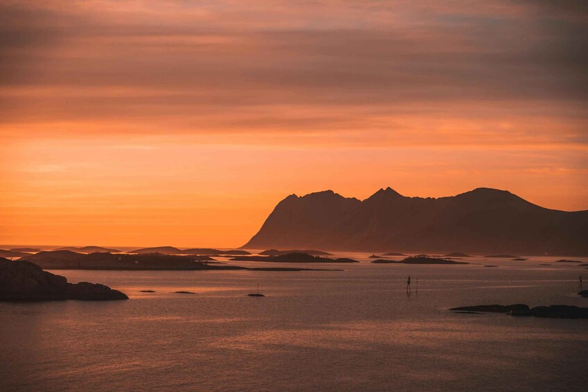 A sunset over a calm sea with distant mountains. 5